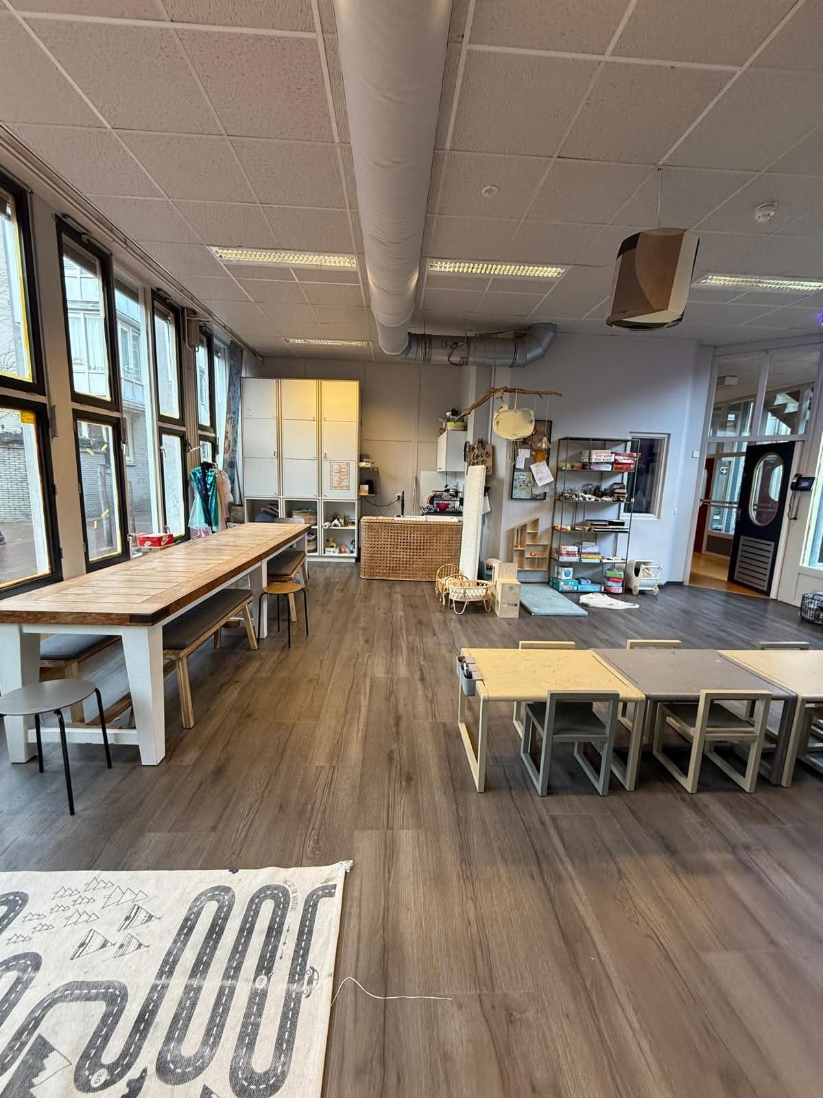Binnenruimte van BSO L’Enfantjes met tafels en speelhoeken